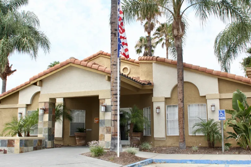 Front entrance, with flag and palmtrees outside the Sienna community in Corona, California