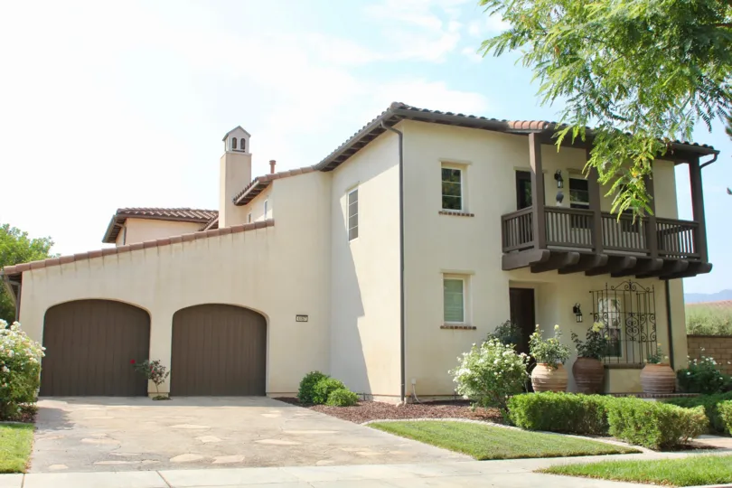 Tuscan villa appearance of this beautiful condo with large potted plants, shrubs and green grass