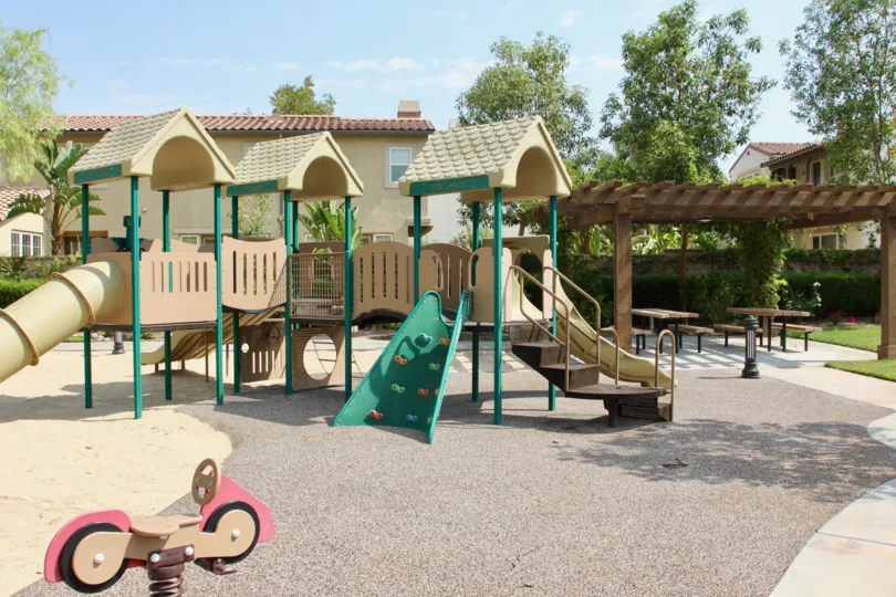 A green ladder sits on a play ground in the Temescal Heights community.
