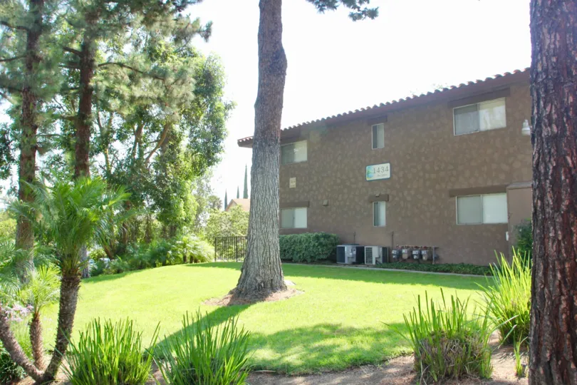 Apartment building and green lawn in The Lakes at Corona community of Corona, CA.