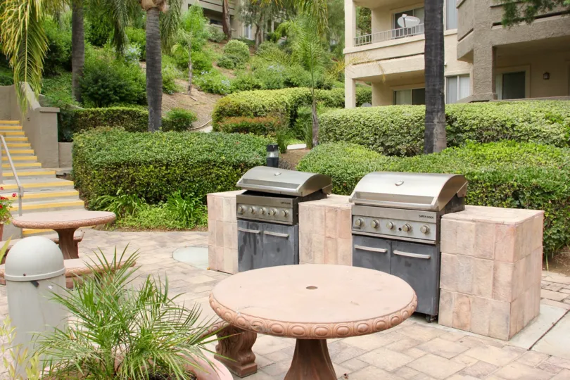 Two outdoor barbecue grills and seating on patio of Triana at Corona Ranch in Corona, CA.