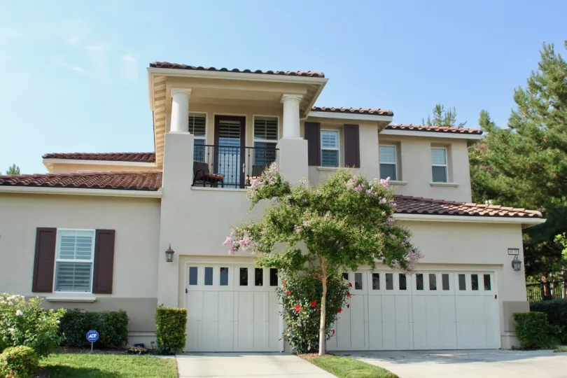 Fancy house garage with beautiful gardening and classic windows with shutters