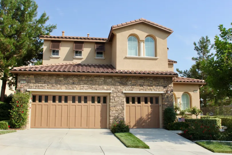 house is constructed with wood and large door is closed and flag is placed in side of house