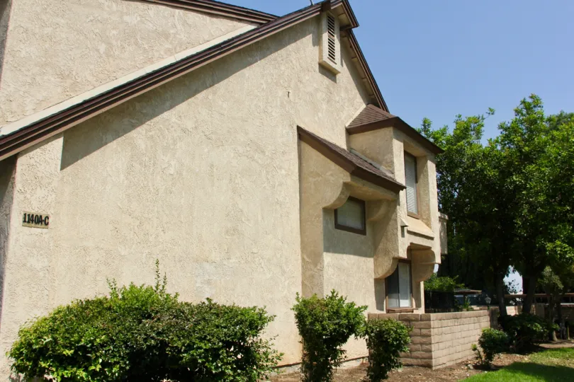 A beautiful beige house with trees in the background in a sunny day