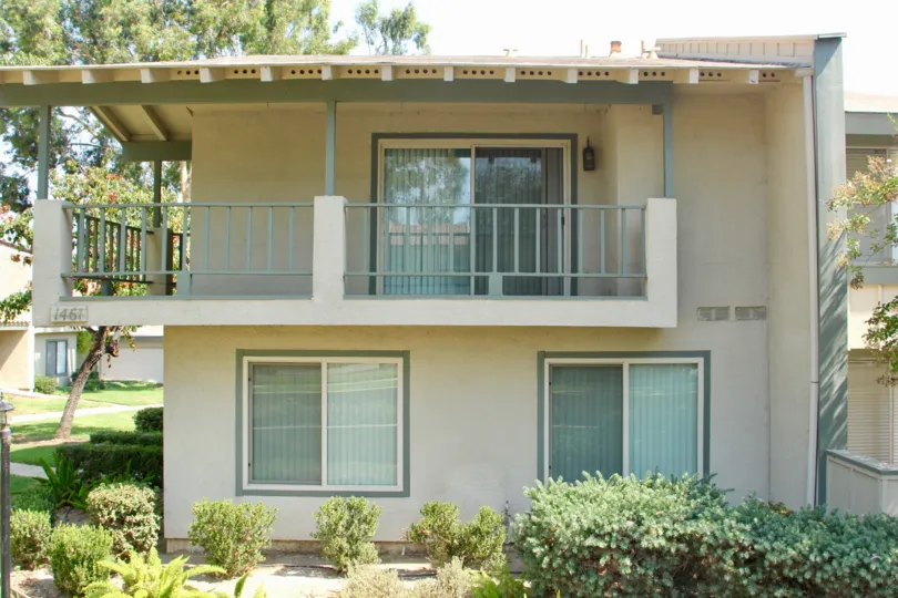 A green metal fence surrounds a balcony at the Village Grove Townhomes.