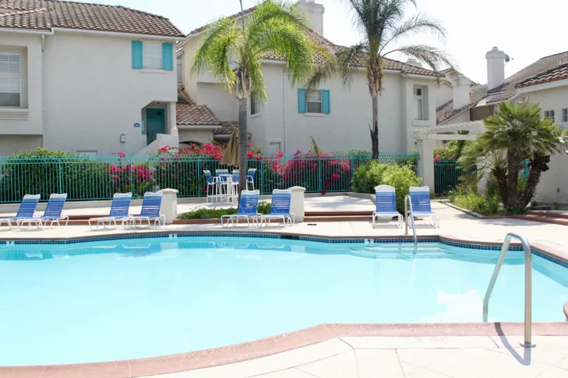 Blue and white lounge chairs sit around the pool at the Villagio community.