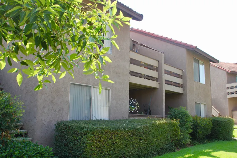 Balcony and patio view of apartments with shrubbery in Windwood community of Corona, CA.