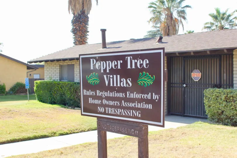 Large sign in front of meager looking house and unfortunate residence with minimal landscaping