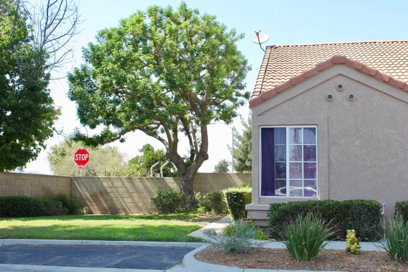 A stop sign sits behind a tan brick fence at a house in Terra Linda Village.