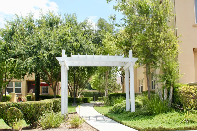 Pretty walkway with Pagonia and trees, trimmed shrubs and landscaped gardens throughout the grounds