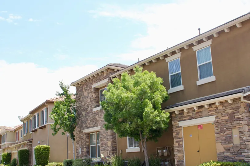this rock building has taup exterior and green trees and natural gas lines are seen