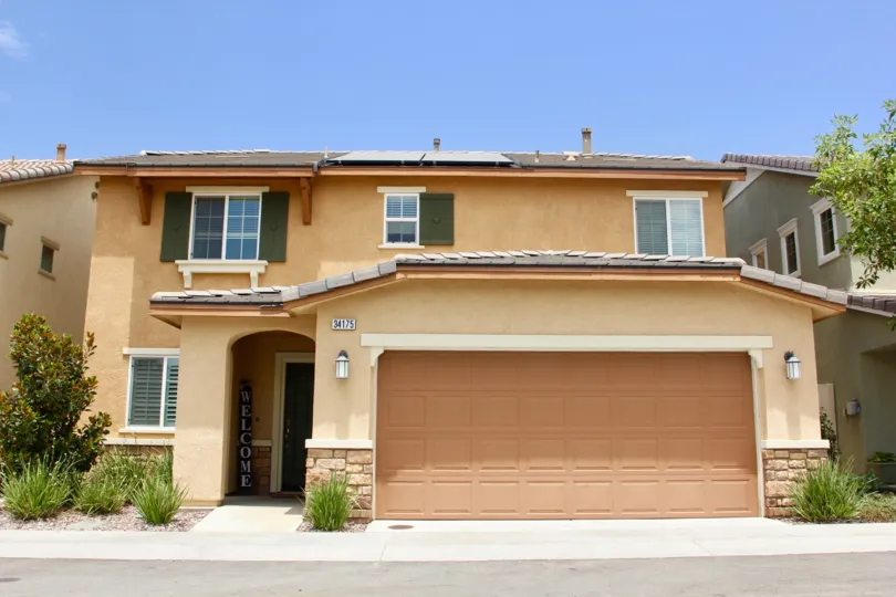 A two-level house with bright beige walls in Cottonwood Canyon Hills community.