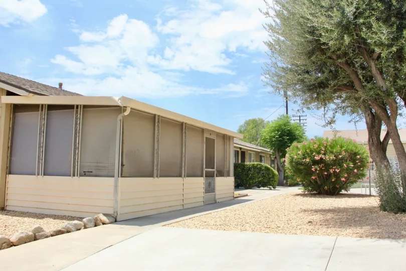 A townhome with a nice walkway lined up with stones and manicured schrubbery