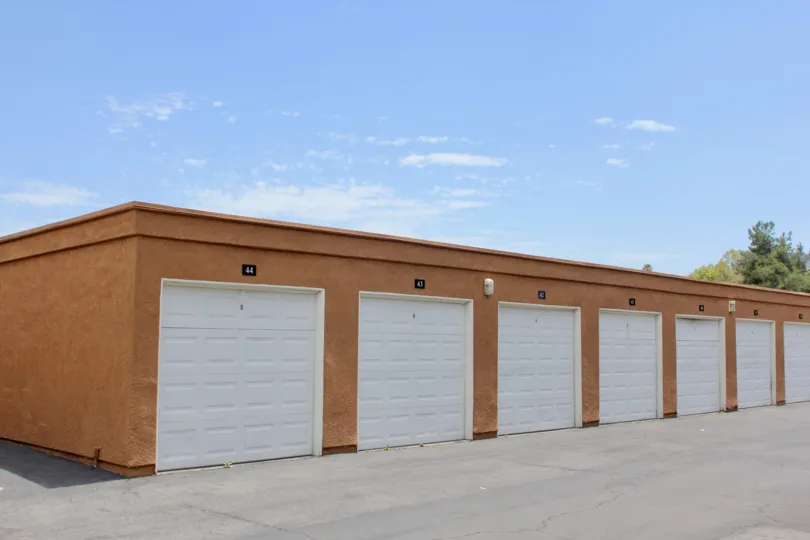Storage units or garages for the use of residents boxy orange structure with parking lot