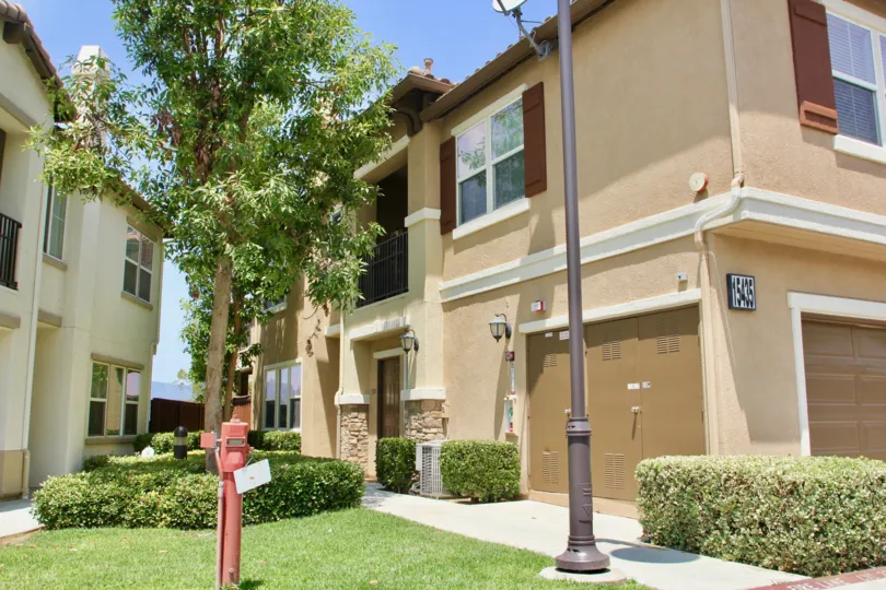 A sunny day in the Vista Del Lago Townhomes a beautiful house and trees.