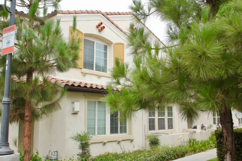 Trees are front of a house with two floors in Aspen Hills community