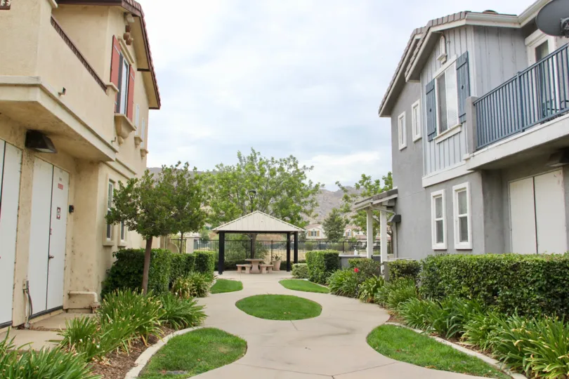 Grey and tan townhomes line the path to the covered table at Iris Landing