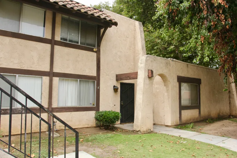 Spanish Pueblo looking architecture with shady grass and large trees