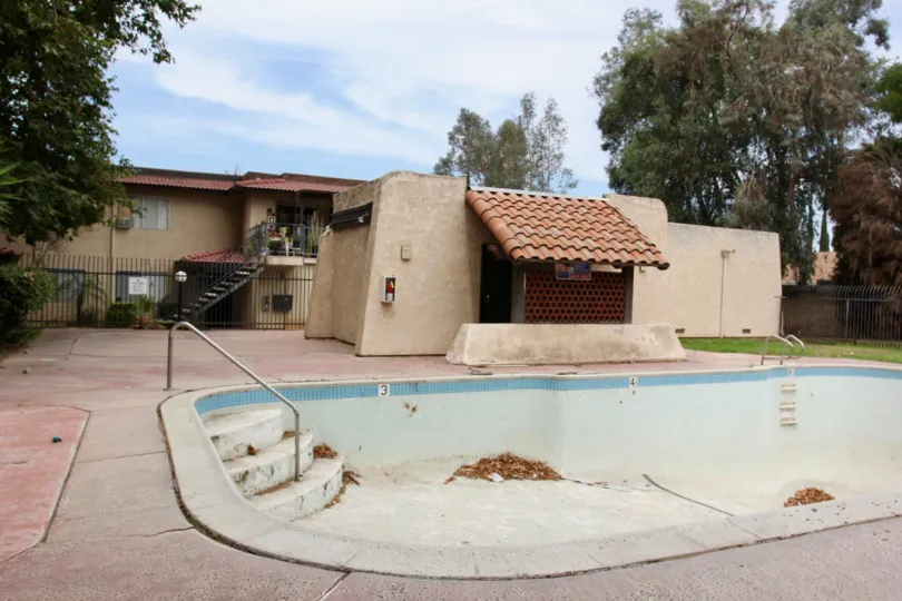 Drained community pool with a dusting of leaves at Lakeview Sunnymead on a pleasant day