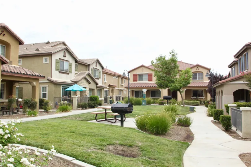 Variety of town houses on an overcast day with grill and picnic table at center
