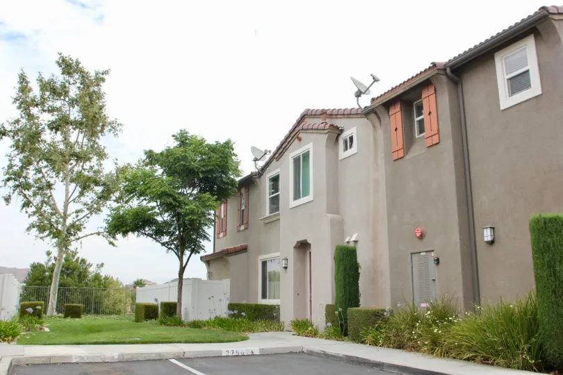 Sattelite Dishes adorn this purple with red shutters Spanish building with parking spaces and landscaping in Promontory Pointe, Moreno Valley CA
