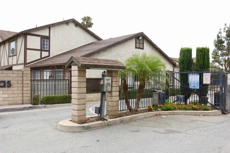 A black iron gate sits near the driveway at the Woodland Villas.