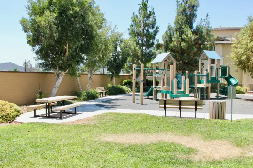 Childrens playground featuring picnic tables, benches and play equipment in Amberwalk at Ivy in Murrieta California