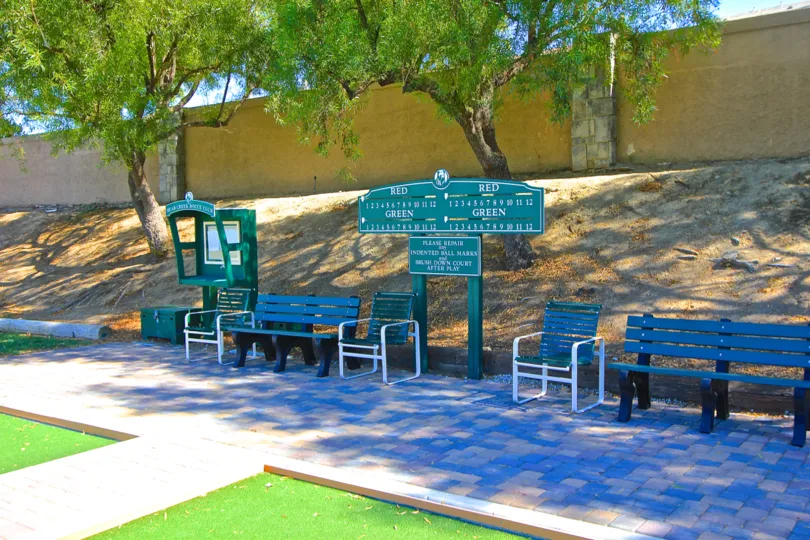 Scoreboard and benches surround the lawn bowling courts of Country Club Villas at Bear Creek