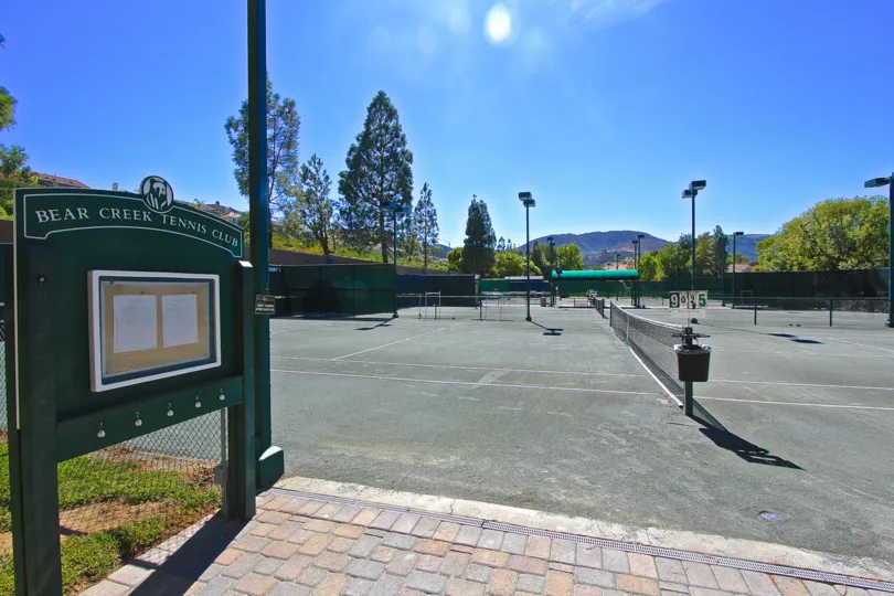 the club is surrounded with full of trees and grasses and at the sunny day