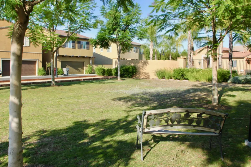 Tan townhouses surround a small park in the Paseos at Crown Valley