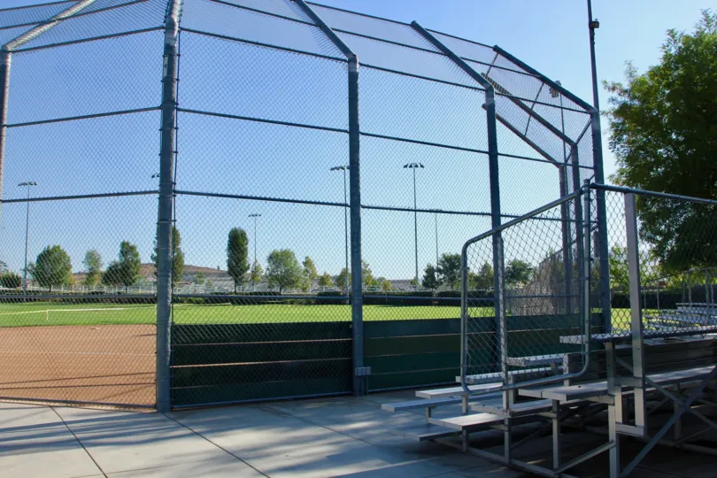 Shaded bleachers await behind home plate at the park by Paseos at Crown Valley in Murrieta, CA