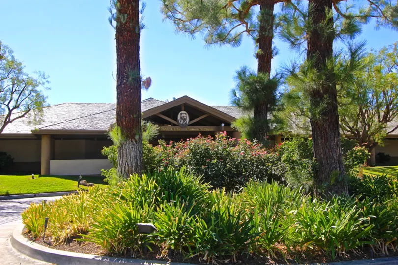 Trees and bushes line a circle in front of a bear themed lodge at the Retreat at Bear Creek
