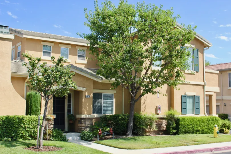 Tan houses in a tree lined street surround the Villas at Old School House
