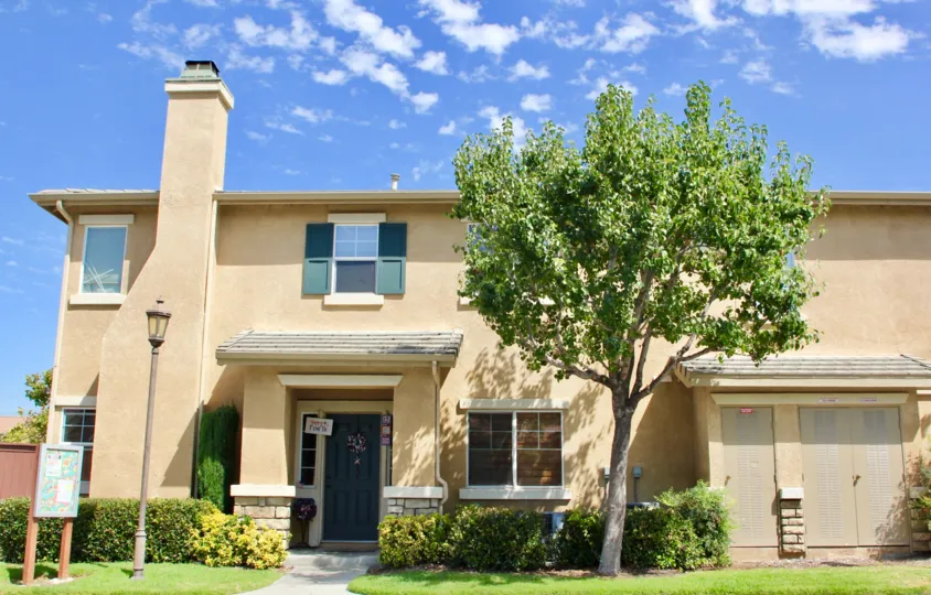 Condo with large trees gardens grounds shutters and chimney