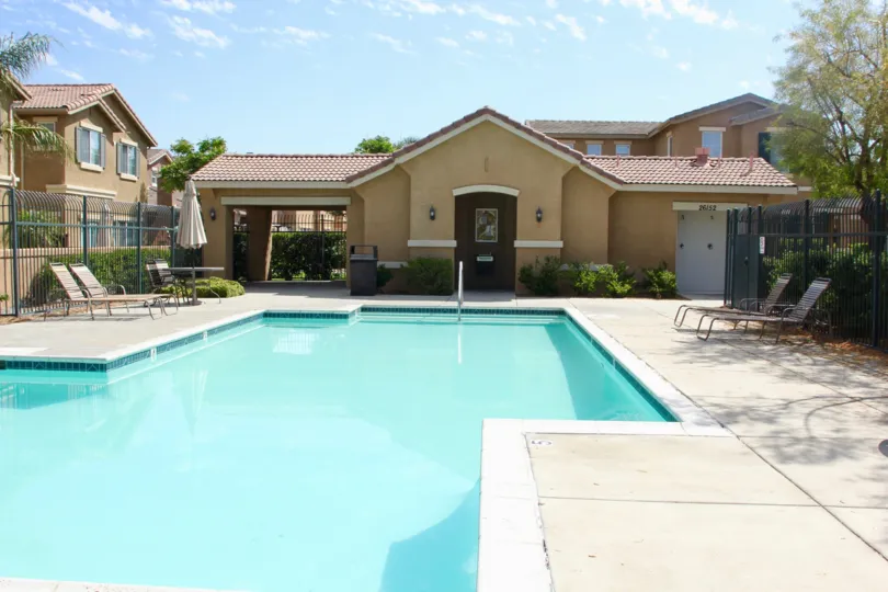 house is located with large swimming pool and there is a chair to be sit and get relaxex abd house is surrounded with full of trees and grasses