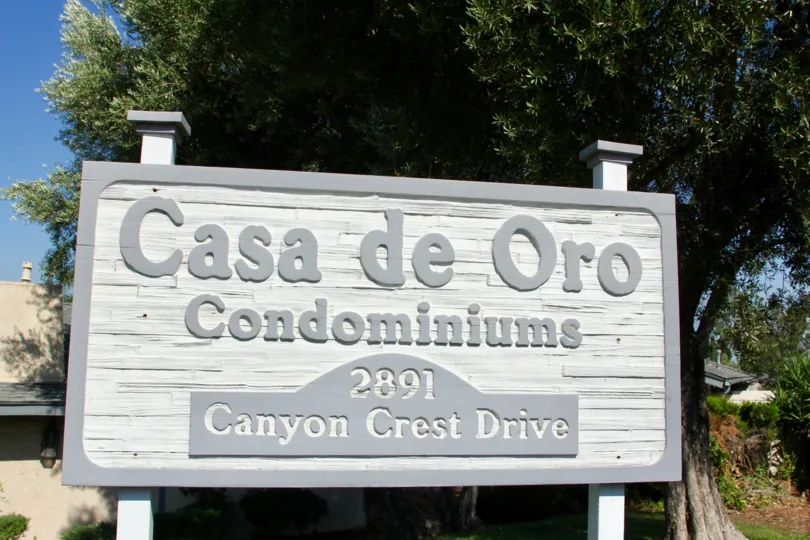 The grey sign with the address of the Casa de Oro Condominiums in Casa de Oro
