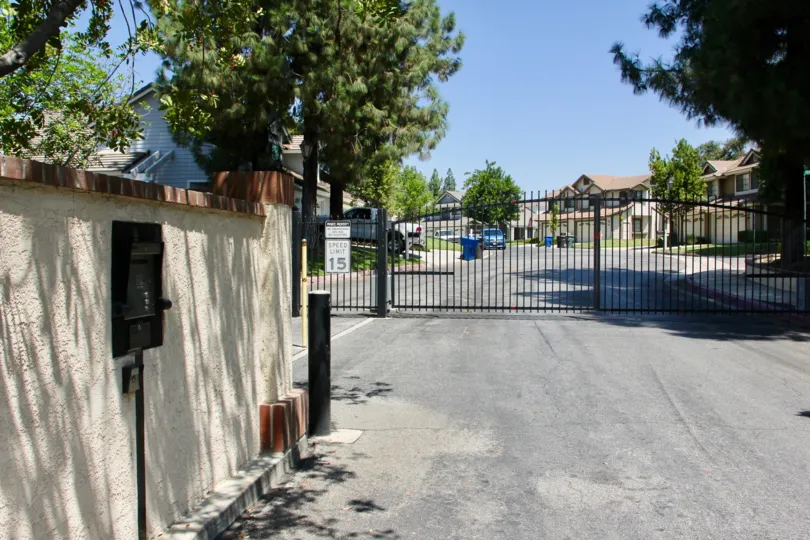 gate is closed and all cars are parked inside the house and dustbin is placed to put waste lot of tree placed