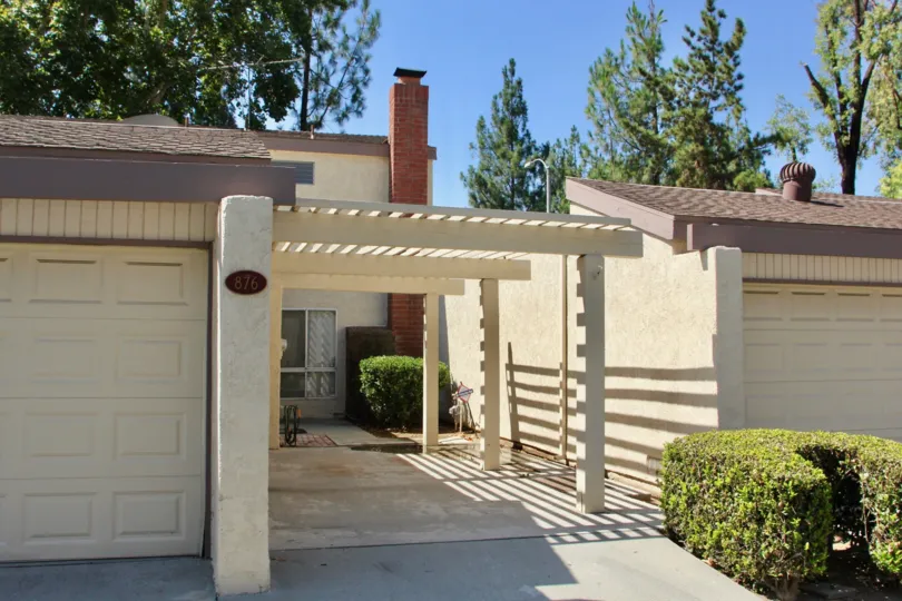 A white painted pergola sits over a walkway at the Crest View Estates.