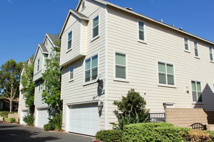 Siding on the house with shrubs and landscaped gardening and two car garages