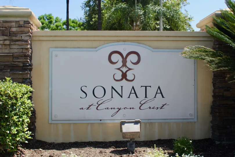 Entrance sign to Sonata at Canyon Crest with landscaping and rock wall