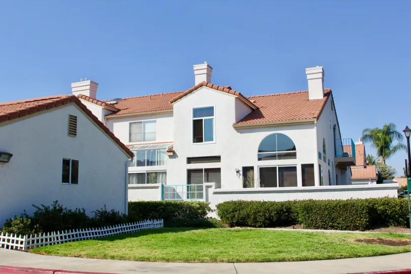 White condos view with manicured lawn and beautiful blue sky