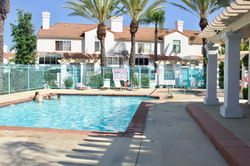 palm tree lined pool area at Rancho Del Mar in Temecula, CA where people swim and sun