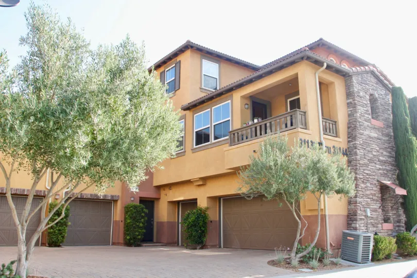 Pretty olive trees and landscaping at this tuscan looking home with four garages