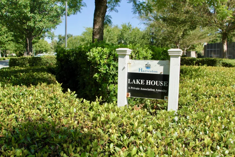 Savannah at Harveston temecula California bussy plants with simple white painted sign board and hided house