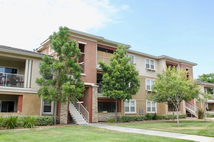 A sunny day at a apartment building in Temecula California with green trees in the mid of summer.