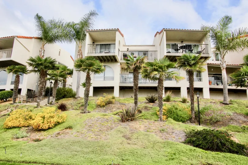 Front view of two-storey townhomes on a hilly landscape in the Alta Mira II neighborhood.