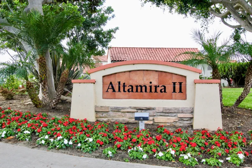 A sunny day in the area of Alta Mira II, welcome sign, trees, flowers, outside, roof, brick