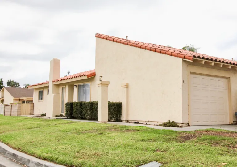 A green lawn with patches of brown in front of an Alta Mira building in Carlsbad CA