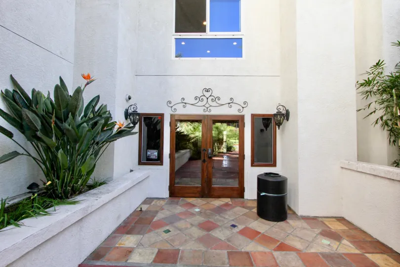 Gorgeous home, gorgeous entry, western style, wood glass front door, tiled entry with lantern lighting on sides, benched green landscaping