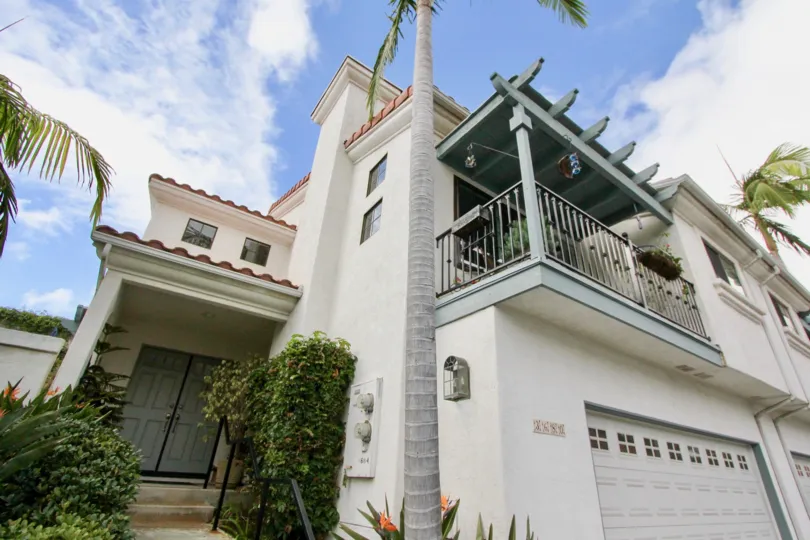 A two-storey residence with white walls and an arbored terrace in the Bel Azure neighborhood.